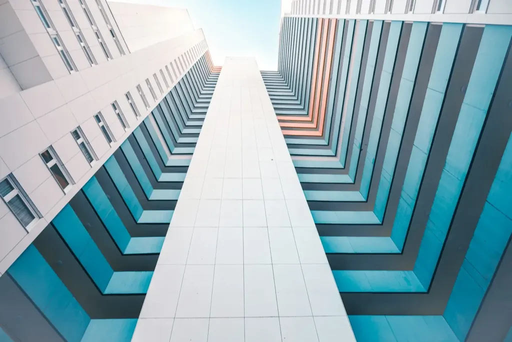 Looking upward between the balconies of a modern apartment building.